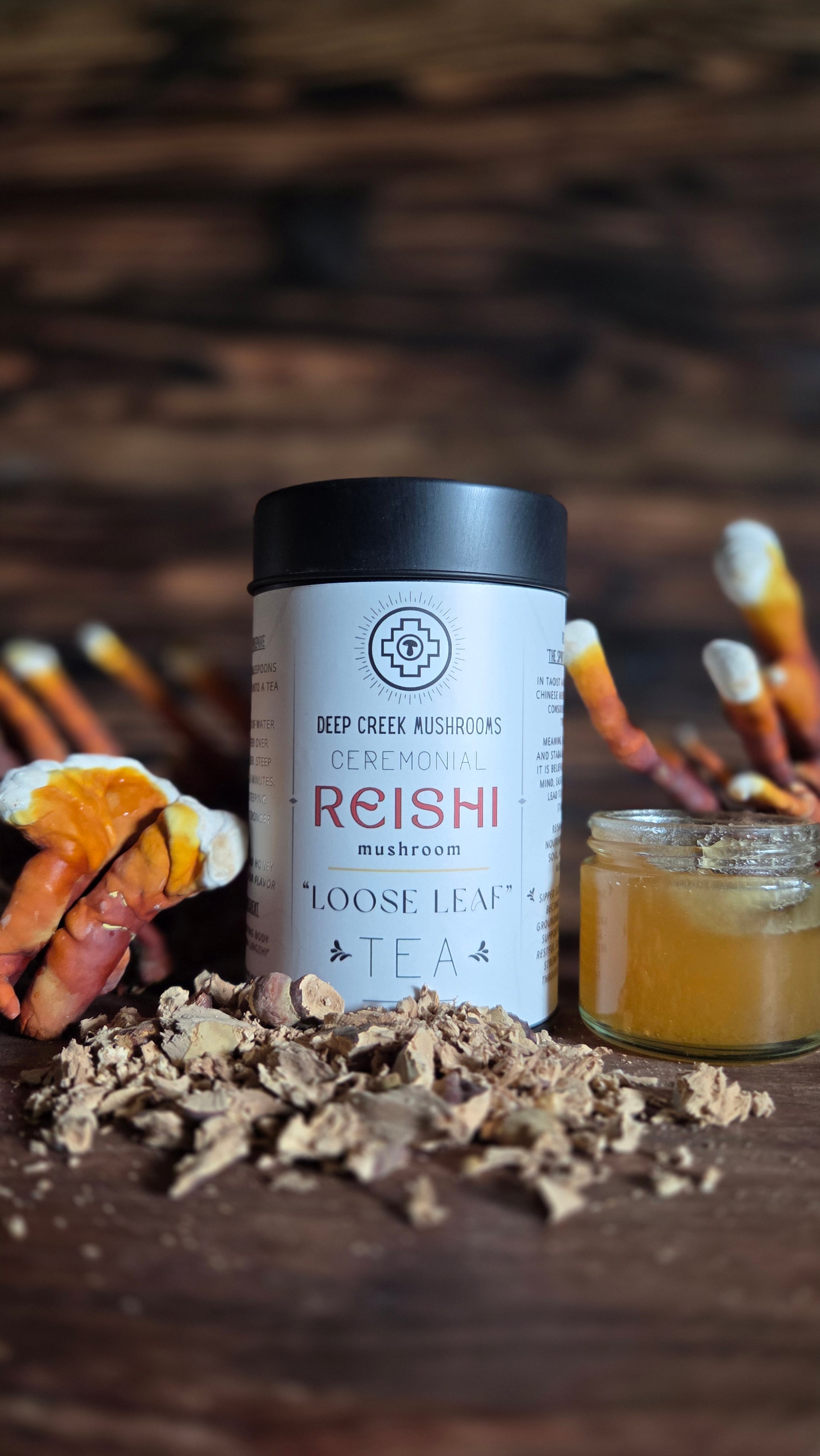 Tea canister labeled 'Reishi' with loose leaf tea on a wooden surface