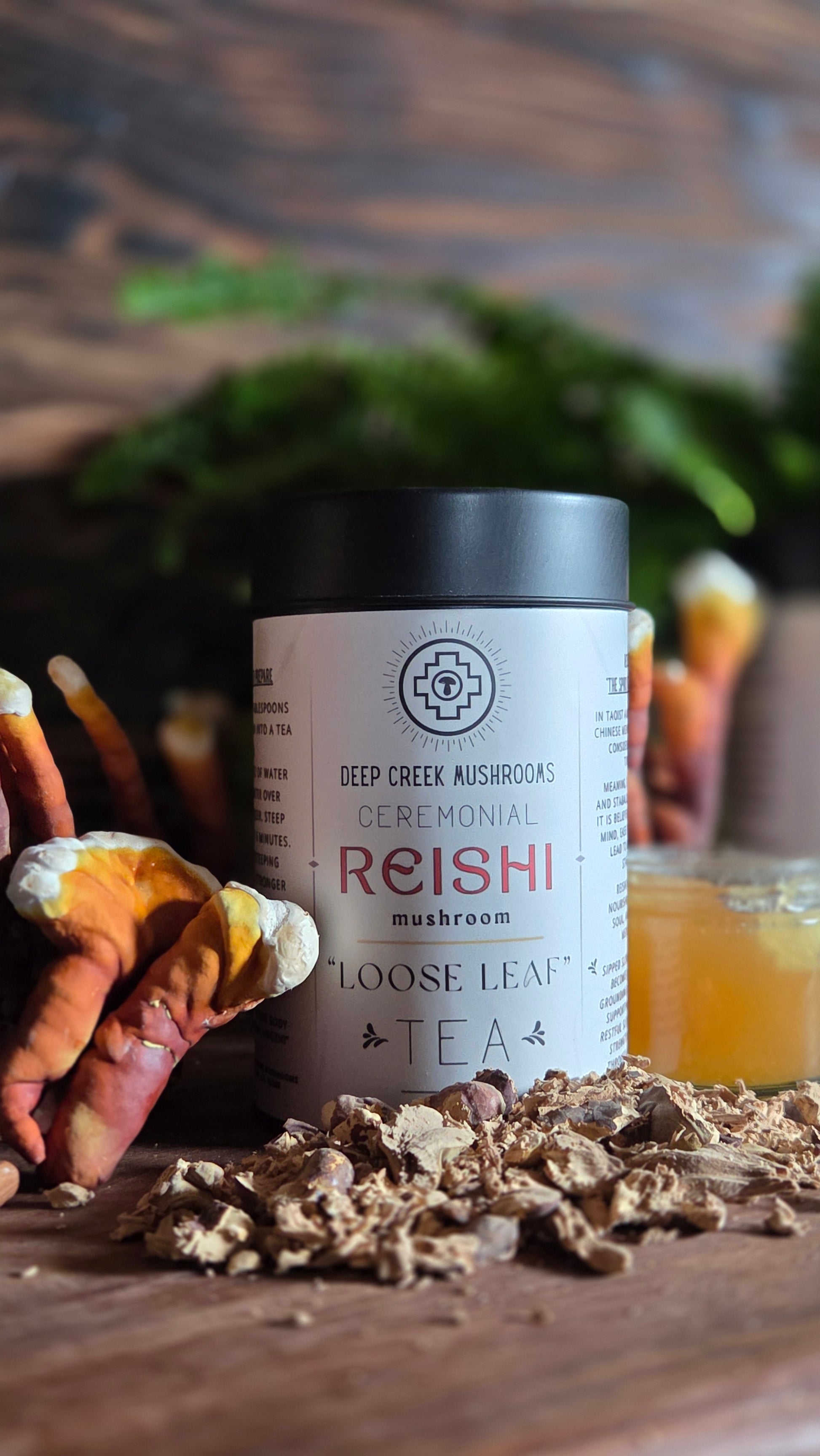 Reishi tea packaging on a wooden surface with decorative elements.