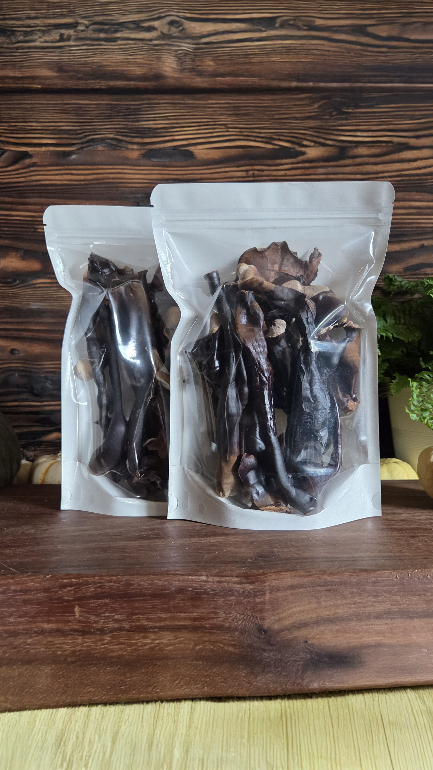 Two packages of dried mushrooms on a wooden surface with a wooden background