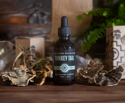 Bottle of Turkey Tail mushroom extract on a wooden surface with dried leaves and a rustic background.